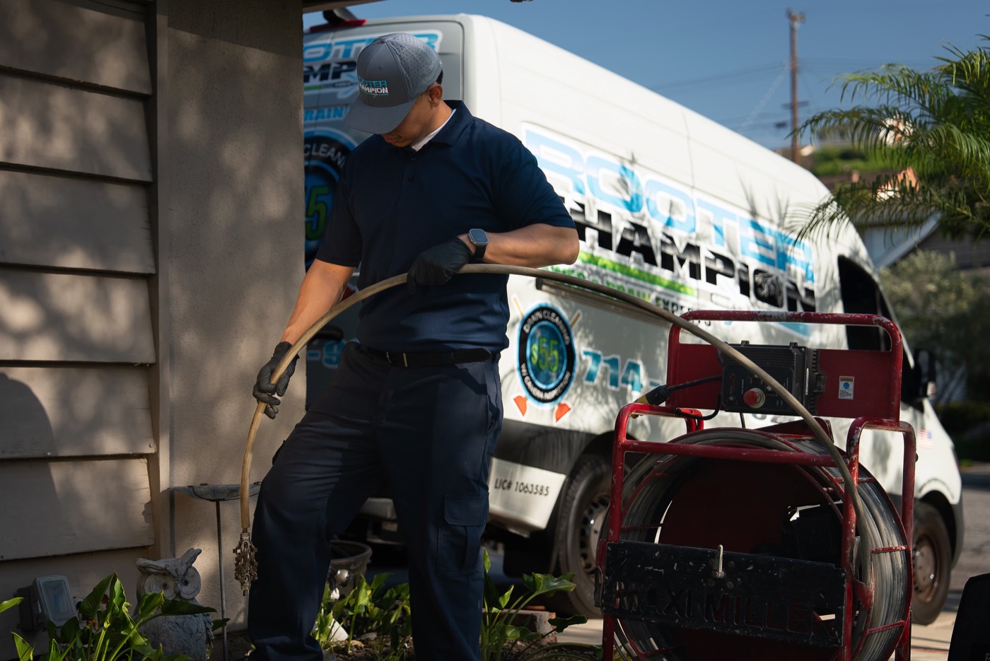Technician feeding a drain cable from a cable machine